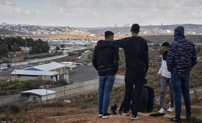 Palestinians look at the Israeli Ofer prison in the West Bank city of Beitunia, Monday Oct. 13, 2025, awaiting the release of Palestinian prisoners as part of a swap for Israelis held hostage in Gaza.(AP Photo/Majdi Mohammed)