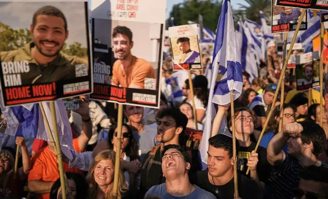 People react as they gather to watch a live broadcast of Israeli hostages released from Gaza at a plaza known as hostages square in Tel Aviv, Israel, Monday, Oct. 13, 2025. The release took place as part of a cease-fire agreement between Israel and Hamas. (AP Photo/Oded Balilty)