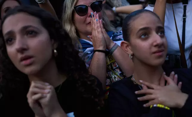 People react as they watch a live broadcast of Israeli hostages released from Hamas captivity in the Gaza Strip, at a plaza known as hostages square in Tel Aviv, Israel, Monday, Oct. 13, 2025. (AP Photo/Oded Balilty)