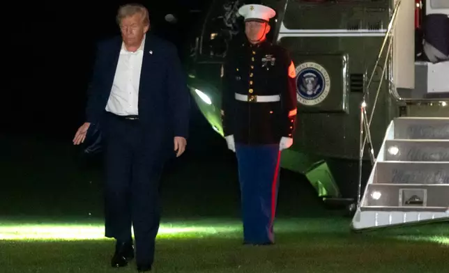 President Donald Trump walks across the South Lawn of the White House, early Tuesday, Oct. 14, 2025, in Washington, after returning from a trip to Israel and Egypt. (AP Photo/Mark Schiefelbein)