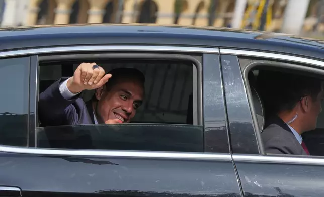 Peru's interim President Jose Jeri wave to the press as he arrives at the government palace in Lima, Peru, Friday, Oct. 10, 2025. (AP Photo/Guadalupe Pardo)