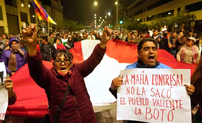 Anti-government demonstrators celebrate outside the congress building in Lima, Peru, Friday, Oct. 10, 2025 as Peru's Congress voted to remove President Dina Boluarte from office. (AP Photo/Martin Mejia)
