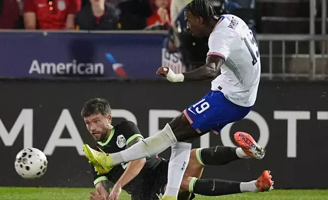 United States forward Haji Wright, front, kicks the ball for a goal as Australia defender Cameron Burgess covers in the second half of an international friendly soccer match Tuesday, Oct. 14, 2025, in Commerce City, Colo.(AP Photo/David Zalubowski)
