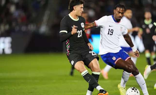 Australia defender Alessandro Circati, left, passes the ball as United States forward Haji Wright defends in the first half of an international friendly soccer match Tuesday, Oct. 14, 2025, in Commerce City, Colo. (AP Photo/David Zalubowski)