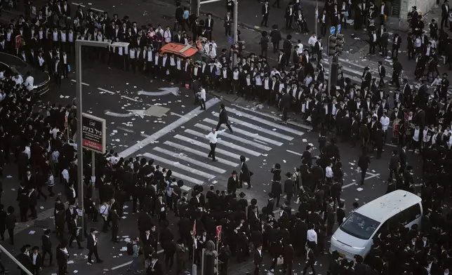 Ultra-Orthodox Jewish men dance during a rally against plans to force them to serve in the Israeli military, in Jerusalem, Thursday, Oct. 30, 2025. (AP Photo/Leo Correa)