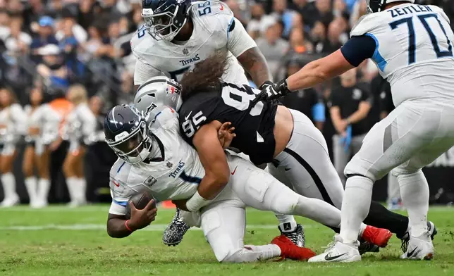 Las Vegas Raiders defensive tackle Leki Fotu (95) sacks Tennessee Titans quarterback Cam Ward (1) during the second half of an NFL football game, Sunday, Oct. 12, 2025, in Las Vegas. (AP Photo/David Becker)