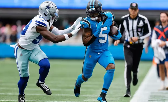 Carolina Panthers running back Rico Dowdle (5) runs the ball as Dallas Cowboys linebacker Kenneth Murray (59) defends in the first half of an NFL football game, Sunday, Oct. 12, 2025, in Charlotte, N.C. (AP Photo/Rusty Jones)