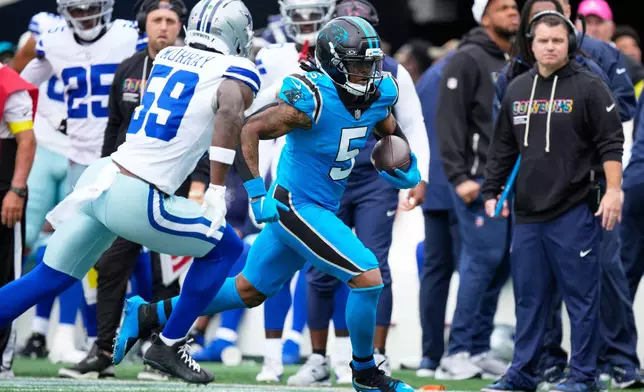 Carolina Panthers running back Rico Dowdle (5) runs the ball as Dallas Cowboys linebacker Kenneth Murray (59) gives chase in the first half of an NFL football game, Sunday, Oct. 12, 2025, in Charlotte, N.C. (AP Photo/Jacob Kupferman)