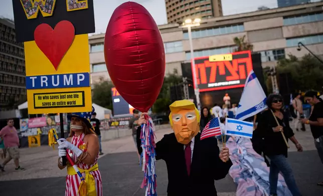 A woman wearing a mask depicting U.S. president Donald Trump attends a rally calling for the release of all hostages held in the Gaza Strip and urges a ceasefire, in Tel Aviv, Israel, Saturday, Oct. 4, 2025. ahead of the second anniversary of the Israel-Hamas war. (AP Photo/Ohad Zwigenberg)