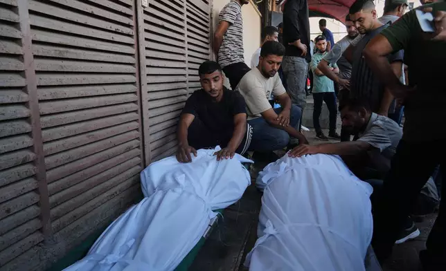 Mourners attend the funeral of Palestinians killed in an Israeli army strike, outside Al-Aqsa Hospital in Deir al-Balah, central Gaza Strip, Saturday, Oct. 4, 2025. (AP Photo/Abdel Kareem Hana)