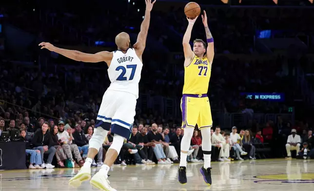 Los Angeles Lakers guard Luka Doncic (77) shoots against the Minnesota Timberwolves center Rudy Gobert (27) during the first half of an NBA basketball game, Friday, Oct. 24, 2025, in Los Angeles. (AP Photo/Jessie Alcheh)