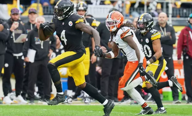 Pittsburgh Steelers wide receiver DK Metcalf (4) is pursued by Cleveland Browns safety Rayshawn Jenkins (5) in the second half of an NFL football game in Pittsburgh, Sunday, Oct. 12, 2025. (AP Photo/Matt Freed)