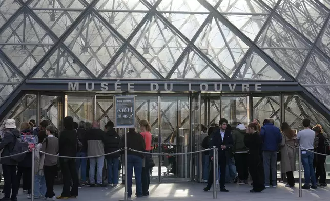Visitors queue to enter the Louvre museum three days after historic jewels were stolen in a daring daylight heist, Wednesday, Oct. 22, 2025 in Paris. (AP Photo/Thibault Camus)
