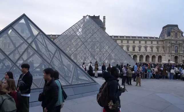 Visitors queue to enter the Louvre museum three days after historic jewels were stolen in a daring daylight heist, Wednesday, Oct. 22, 2025 in Paris. (AP Photo/Thibault Camus)
