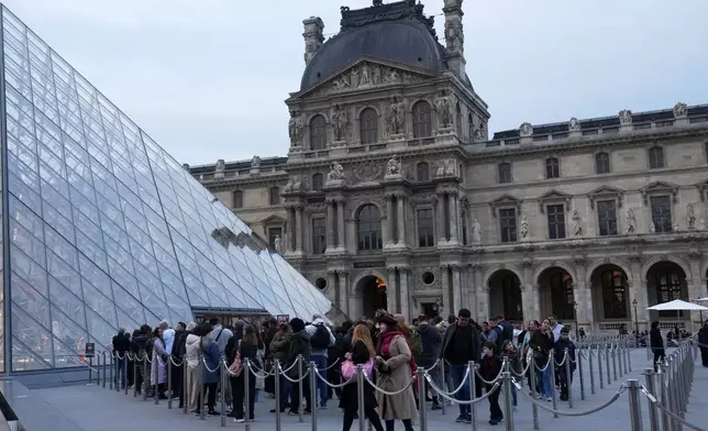 Visitors queue to enter the Louvre museum three days after historic jewels were stolen in a daring daylight heist, Wednesday, Oct. 22, 2025 in Paris. (AP Photo/Thibault Camus)