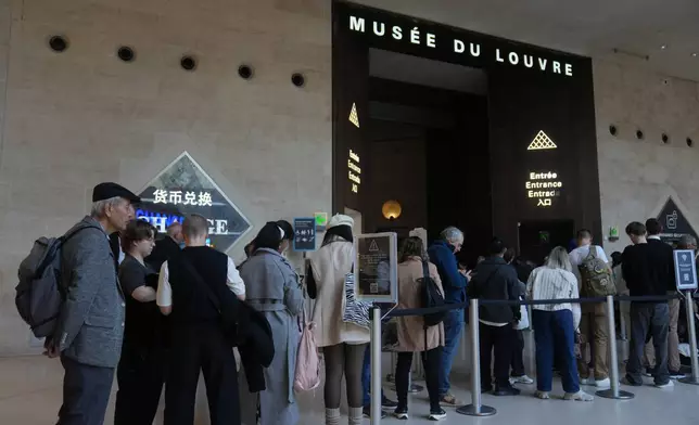 Visitors queue inside the Louvre museum three days after historic jewels were stolen in a daring daylight heist, Wednesday, Oct. 22, 2025 in Paris. (AP Photo/Thibault Camus)