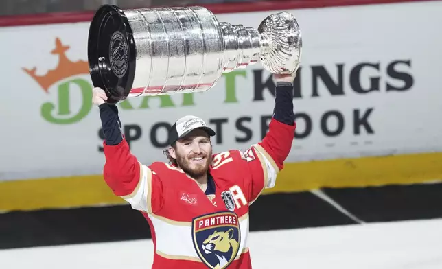 Florida Panthers' Matthew Tkachuk (19) raises the Stanley Cup after defeating the Edmonton Oilers in Game 6 of the NHL hockey Stanley Cup Final in Sunrise, Fla., Tuesday, June 17, 2025. (Nathan Denette/The Canadian Press via AP)