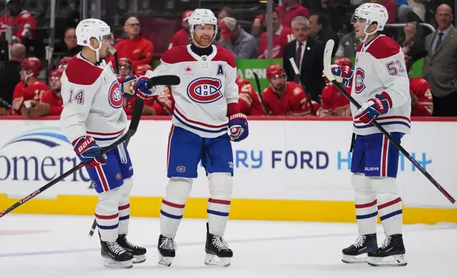 Montreal Canadiens defenseman Mike Matheson, center, celebrates his goal with Nick Suzuki (14) and Noah Dobson (53) against the Detroit Red Wings in the first period of an NHL hockey game Thursday, Oct. 9, 2025, in Detroit. (AP Photo/Paul Sancya)