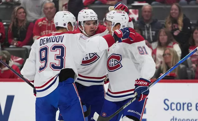 Montreal Canadiens center Oliver Kapanen (91) celebrates his goal with Ivan Demidov (93) and Alex Newhook (15) in the first period of an NHL hockey game Thursday, Oct. 9, 2025, in Detroit. (AP Photo/Paul Sancya)