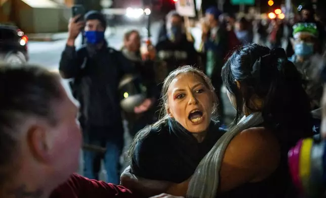 A protester yells at police and federal officers during a protest at a U.S. Immigration and Customs Enforcement facility in Portland, Ore. on Sunday, October. 5, 2025. (AP Photo/Ethan Swope)