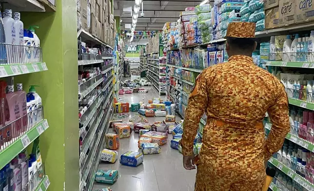 In this photo provided by the Bureau of Fire Protection, a fireman stands near the items on the floor at a grocery following a strong earthquake in Banaybanay, southern Philippines on Friday Oct. 10, 2025. (Bureau of Fire Protection via AP)