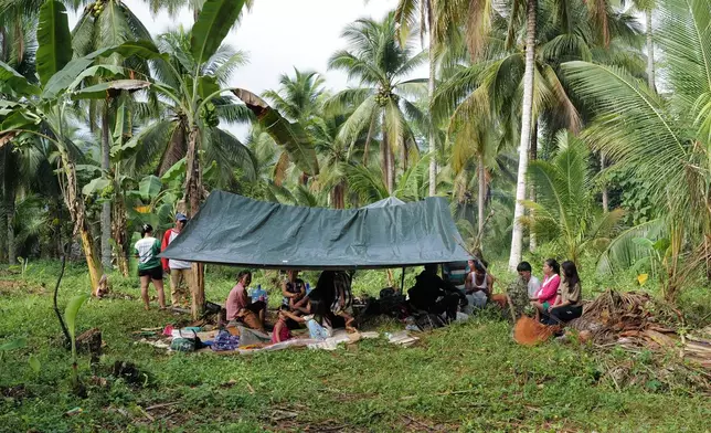 Residents stay under a tent at the earthquake-hit Manay town, Davao Oriental province, southern Philippines Saturday, Oct. 11, 2025. (AP Photo/Jeoffrey Maitem)
