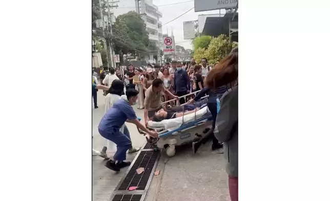 Health workers rush a person injured by an earhtquake to a hospital compound in Davao city, Philippines Friday, Oct. 10, 2025. (Meggy Macion Santos via AP)