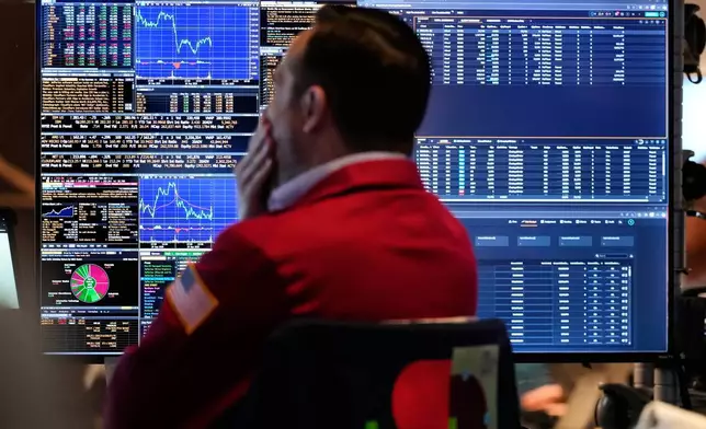 A trader looks at financial information on his computer on the floor at the New York Stock Exchange in New York, Wednesday, Oct. 1, 2025. (AP Photo/Seth Wenig)