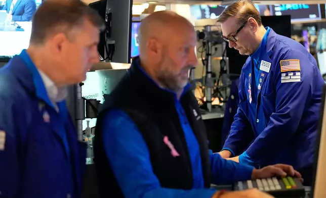 Patrick King, right, and others work on the floor at the New York Stock Exchange in New York, Wednesday, Oct. 1, 2025. (AP Photo/Seth Wenig)