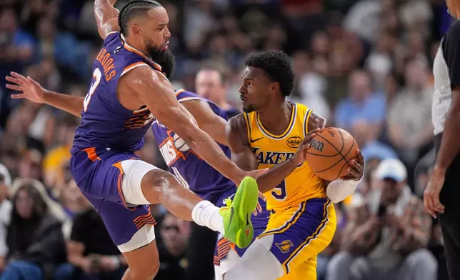 Los Angeles Lakers guard Bronny James, right, tries to pass while under pressure from Phoenix Suns forward Dillon Brooks during the second half of an NBA preseason basketball game Friday, Oct. 3, 2025, in Palm Desert, Calif. (AP Photo/Mark J. Terrill)