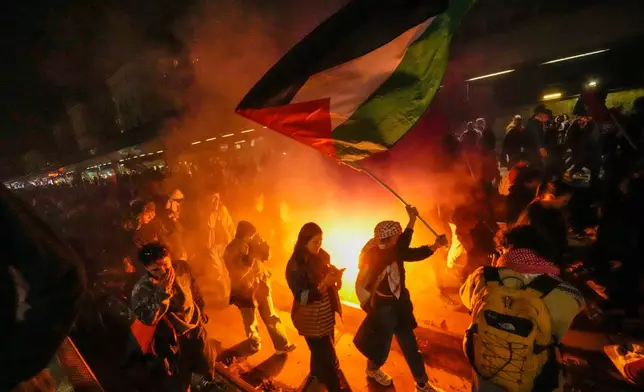 Pro-Palestinian demonstrators flood the rail track at Milan's Cadorna railway station, Italy, late Wednesday, Oct. 1, 2025, after news that a Gaza-bound aid flotilla had been intercepted by Israeli forces in the Mediterranean Sea. (AP Photo/Luca Bruno)