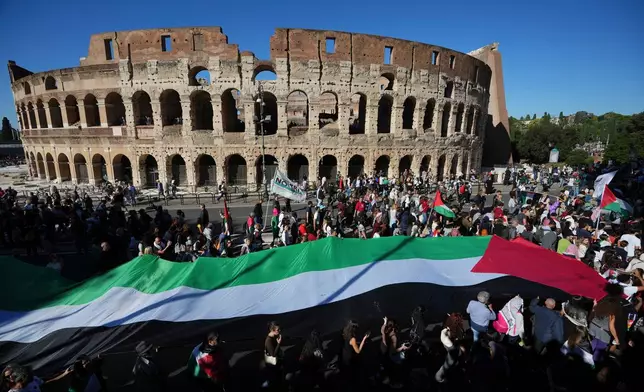 Pro-Palestinian demonstrators march in front of the Colosseum during a national demonstration in support of the population of Gaza, in Rome, Saturday, Oct. 4, 2025. (AP Photo/Alessandra Tarantino)