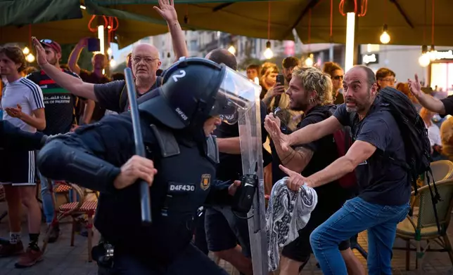 Police officers clash with protesters during a pro-Palestinian rally in solidarity with the Global Sumud Flotilla after ships were intercepted by the Israeli navy, in Barcelona, Spain, Saturday, Oct. 4, 2025. (AP Photo/Emilio Morenatti)