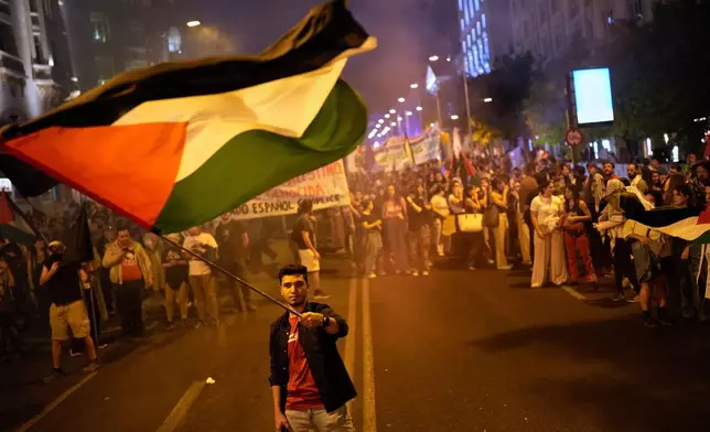 A pro-Palestinian demonstrator waves a Palestinian flag during a protest in Madrid, Spain, Thursday, Oct. 2, 2025, in solidarity with the Global Sumud Flotilla after ships were intercepted by the Israeli navy. (AP Photo/Bernat Armangue)
