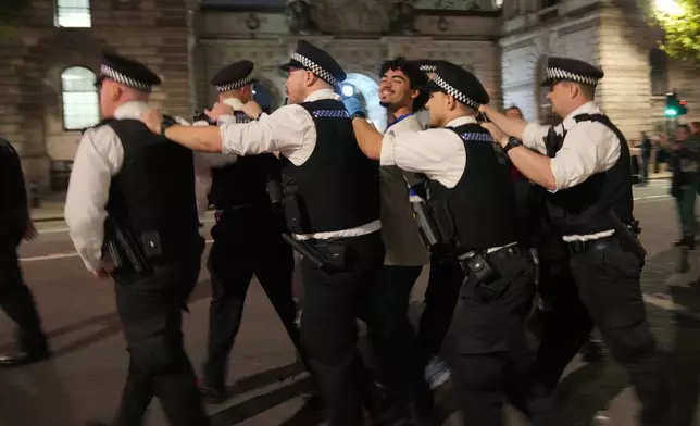 A Palestinian supporter is arrested by police during a protest in London, Thursday, Oct. 2, 2025. (AP Photo/Kin Cheung)