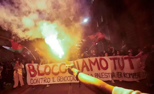 Pro-Palestinians demonstrators march in downtown Milan late Wednesday, Oct. 1, 2025, after news that a Gaza-bound aid flotilla had been intercepted by Israeli forces in the Mediterranean Sea. (AP Photo/Luca Bruno)