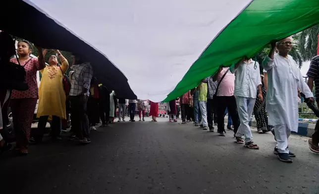 Demonstrators hold a giant Palestinian flag during a rally in solidarity with the Global Sumud Flotilla after ships were intercepted by the Israeli navy, in Kolkata, India, Saturday, Oct. 4, 2025. (AP Photo/Bikas Das)