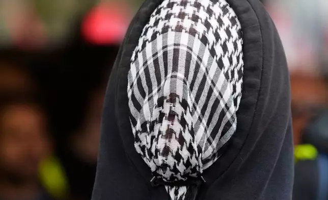 A pro-Palestinian demonstrator gathers for a national general strike called by different unions to protest against the situation in Gaza two days after Israeli forces intercepted a Gaza-bound aid flotilla in the Mediterranean Sea, in Milan, Italy, Friday, Oct. 3, 2025. (AP Photo/Luca Bruno)