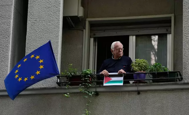 A man looks pro-Palestinian demonstrators gathering for a national general strike called by different unions to protest against the situation in Gaza two days after Israeli forces intercepted a Gaza-bound aid flotilla in the Mediterranean Sea, in Milan, Italy, Friday, Oct. 3, 2025. (AP Photo/Luca Bruno)