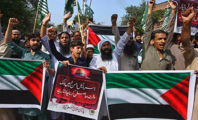 Supporters of Pakistan Muslim League (Nazaryati) chant anti Israel slogans during a demonstration against the situation in Gaza after Israeli forces intercepted a Gaza-bound aid flotilla in the Mediterranean Sea, in Peshawar, Pakistan, Friday, Oct. 3, 2025. The placard, center in Urdu language, reads "Israel obtaining time, not peace." (AP Photo/Muhammad Sajjad)