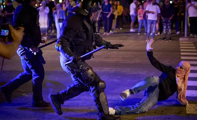Police officers clash with protesters during a pro-Palestinian rally in solidarity with the Global Sumud Flotilla after ships were intercepted by the Israeli navy, in Barcelona, Spain, Saturday, Oct. 4, 2025. (AP Photo/Emilio Morenatti)