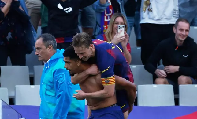 Barcelona's Frenkie de Jong hugs Ronald Araujo after a goa; during a La Liga soccer match between Barcelona and Girona in Barcelona, Spain, Saturday, Oct. 18, 2025. AP Photo/Joan Monfort)