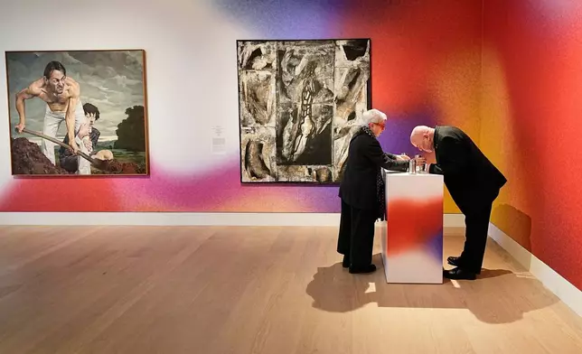 People smell samples of the former East Germany GDR during the exhibition "The Secret Power of Scents", showing the history of scent from antiquity to the present as a sensory experience at the Kunstpalast art museum in Duesseldorf, Germany, Tuesday, Oct. 28, 2025. (AP Photo/Martin Meissner)