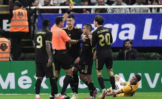 Referee Juan Calderon shows a yellow card to Mexico's Érick Sánchez during a friendly soccer match against Ecuador at Akron stadium in Guadalajara, Mexico, Tuesday, Oct. 14, 2025. (AP Photo/Eduardo Verdugo)