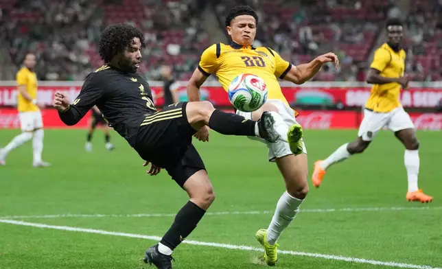 Mexico's César Huerta, left, and Ecuador's Patrik Mercado compete for the ball during a friendly soccer match at Akron stadium in Guadalajara, Mexico, Tuesday, Oct. 14, 2025. (AP Photo/Eduardo Verdugo)
