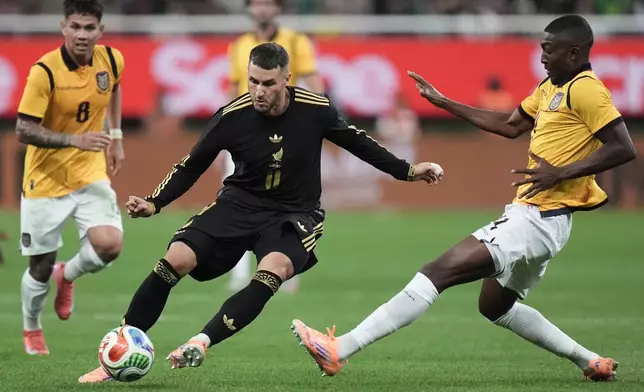 Mexico's Santiago Gimenez, center, is challenged by Ecuador's Joel Ordóñez, right, during a friendly soccer match at Akron stadium in Guadalajara, Mexico, Tuesday, Oct. 14, 2025. (AP Photo/Eduardo Verdugo)