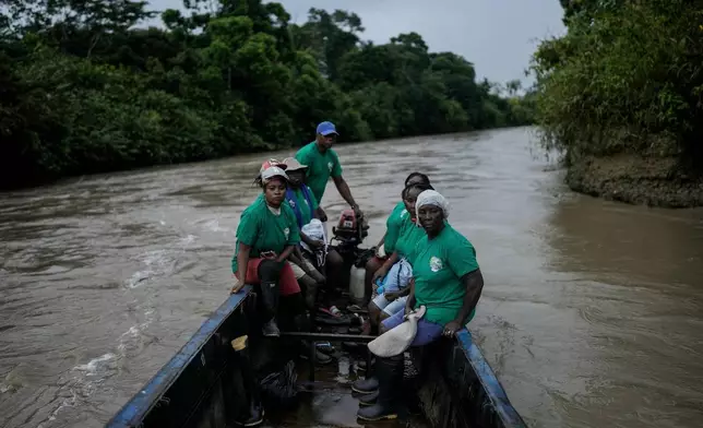 FILE - A group of women, part of Asociacion Nuestra Casa Comun, or Our Community House Association, go by boat to an area destroyed by illegal mining, on the Quito River, the Atrato River's main tributary, near Paimado, Colombia, Sept. 24, 2024. (AP Photo/Ivan Valencia, File)