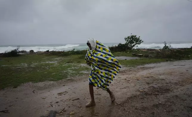A man walks in the rain before the arrival of Hurricane Melissa in Canizo, a village in Santiago de Cuba, Tuesday, Oct. 28, 2025. (AP Photo/Ramón Espinosa)