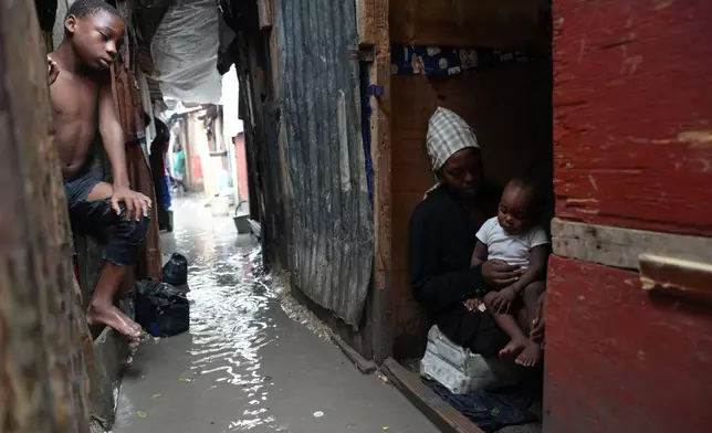 People stay inside a shelter for families displaced by gang violence, flooded by rain brought by Hurricane Melissa, in Port-au-Prince, Haiti, Wednesday, Oct. 29, 2025. (AP Photo/Odelyn Joseph)