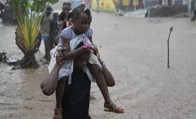 Residents wade through a flooded street in the aftermath of Hurricane Melissa in Petit-Goave, Haiti, Thursday, Oct. 30, 2025. (AP Photo/Odelyn Joseph)